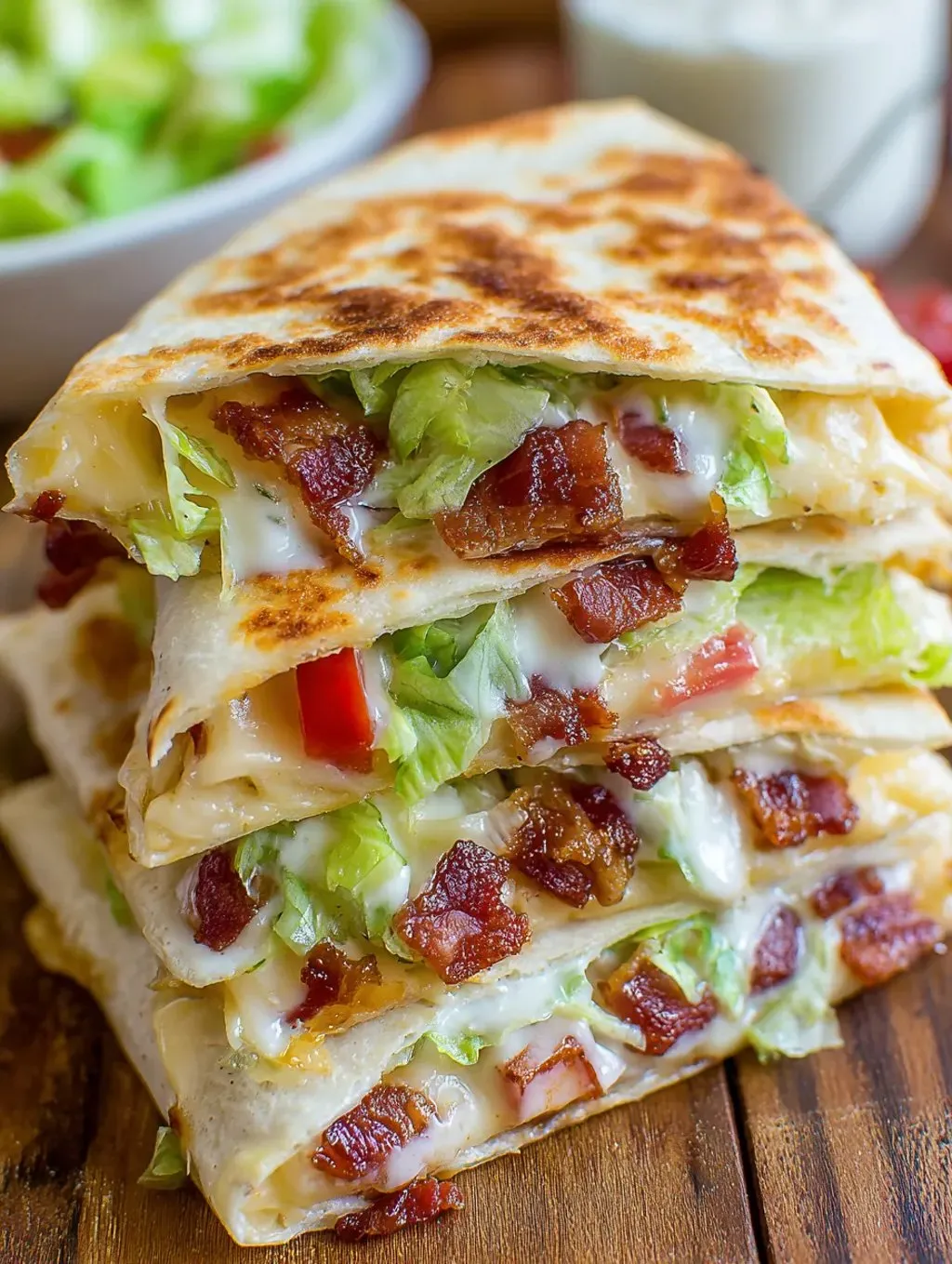 A pile of sandwiches with bacon and lettuce showing.