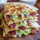 A pile of sandwiches stuffed with bacon and lettuce.