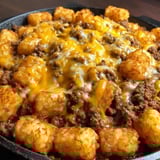 A pan loaded with tots over beefy filling.