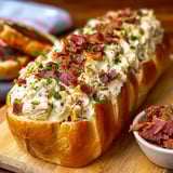A sandwich with bacon and cheese on a bun.