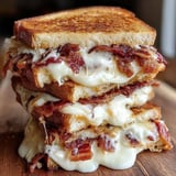 Three grilled cheese sandwiches stacked up.