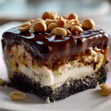 Piece of chocolate dessert topped with nuts.