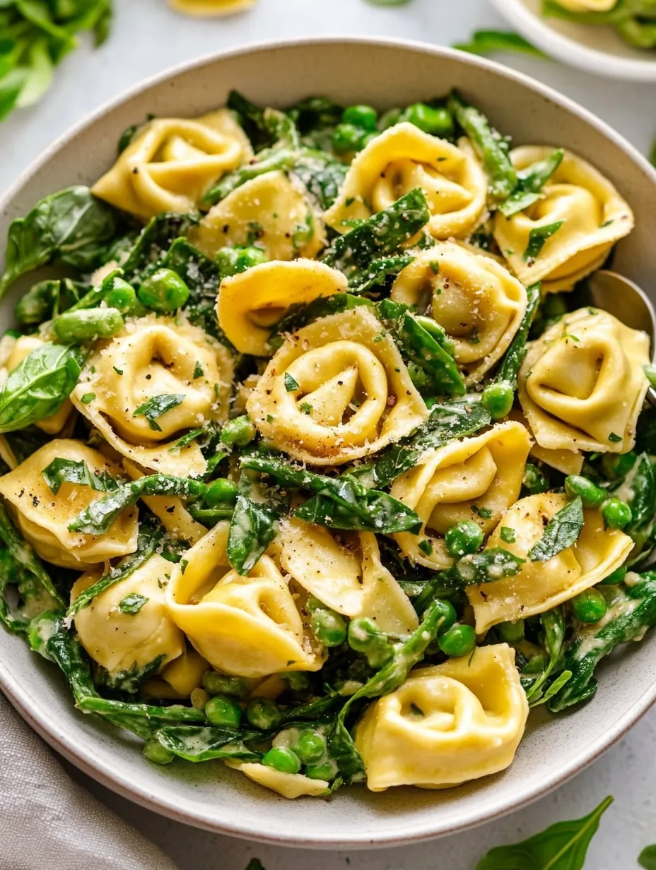 A bowl of pasta with green vegetables.
