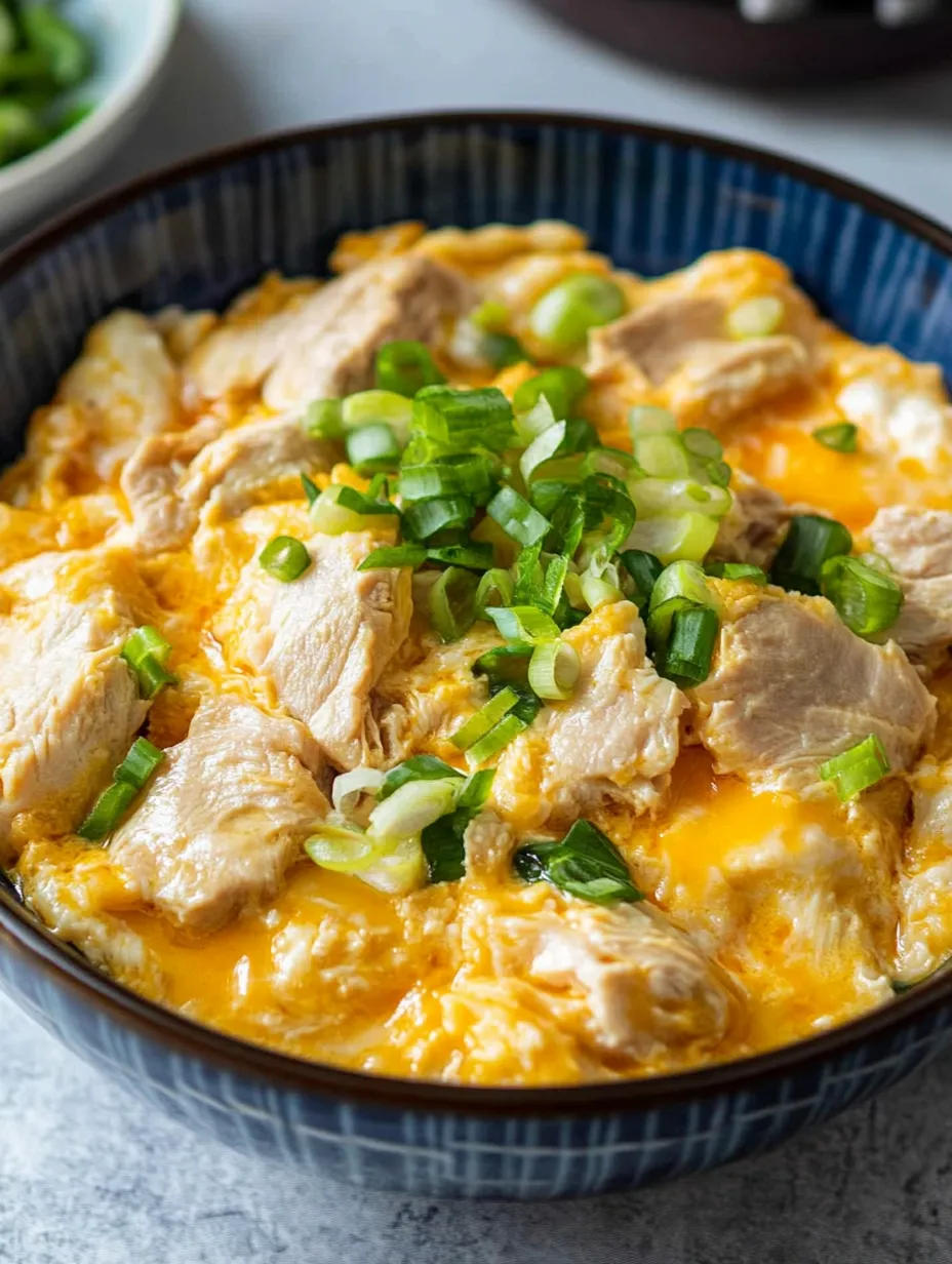 A bowl of food with green onions on top.