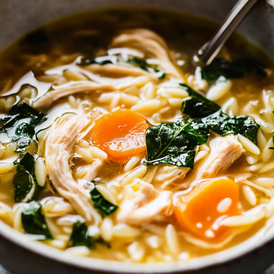 A bowl of soup with chicken and vegetables.
