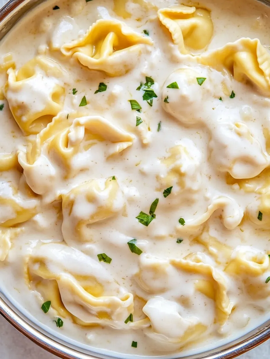 A bowl of pasta with white sauce.