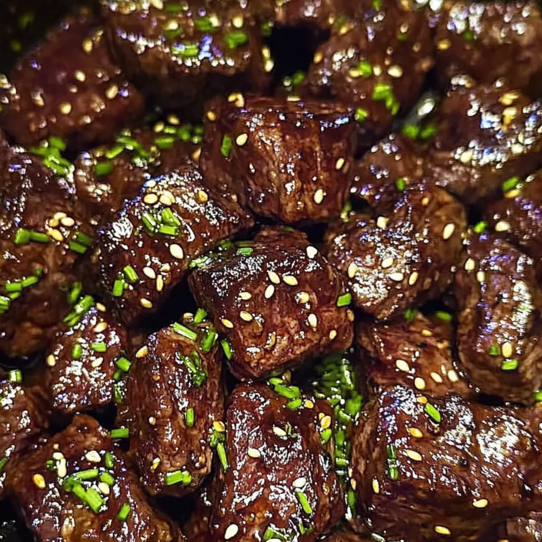 Close view of beef bites topped with fresh herbs.