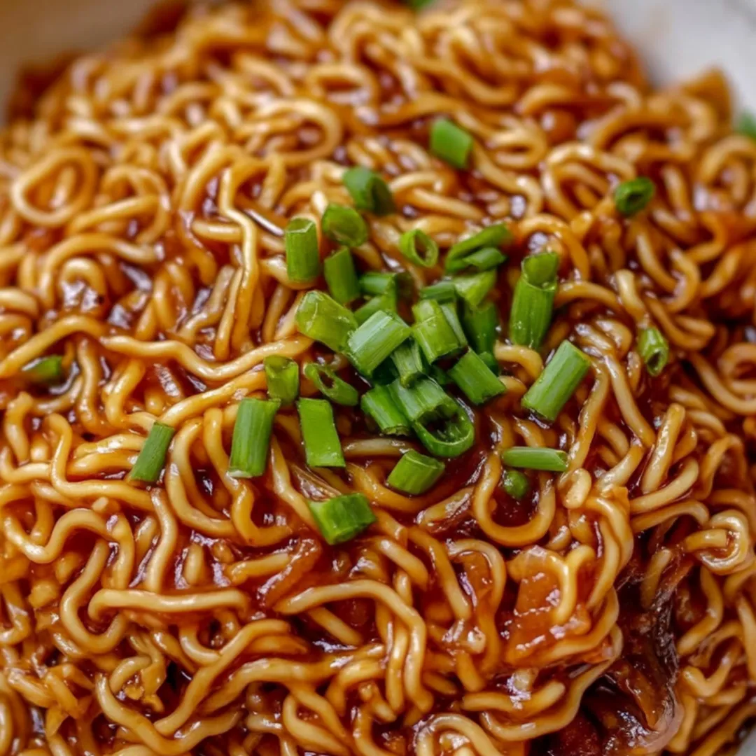 Noodles in a bowl finished with chopped green onions.