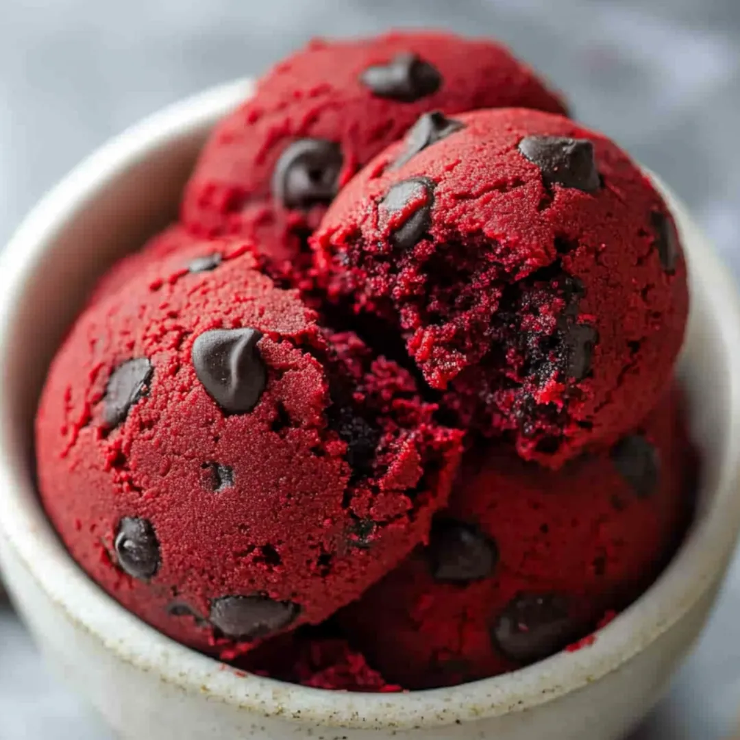 Bright bowls of red velvet dough loaded with chocolate chips.
