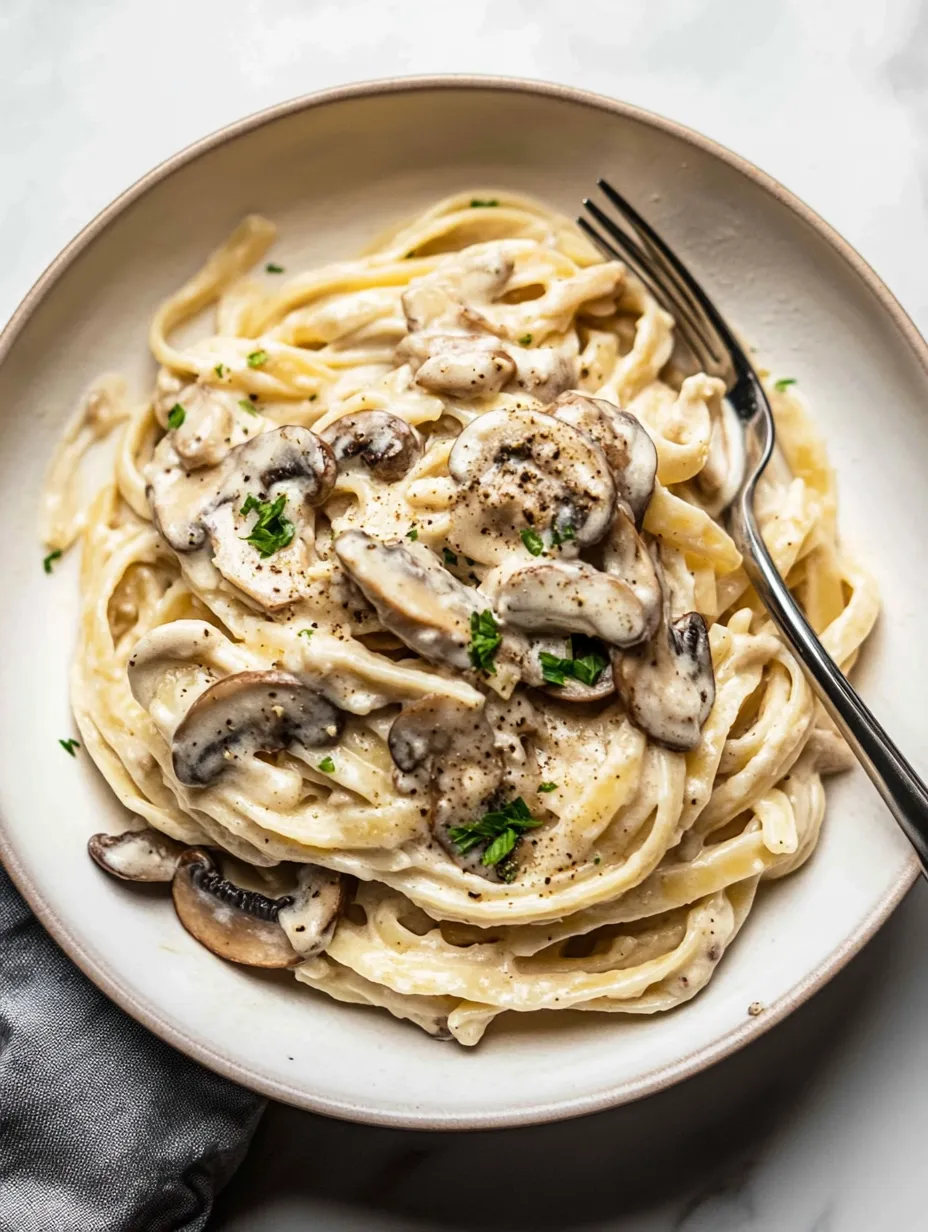 A bowl of pasta with mushrooms and cheese.