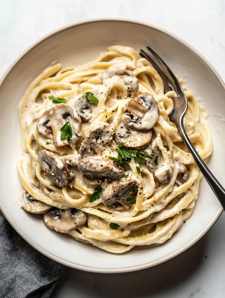A bowl of pasta with mushrooms and cheese.