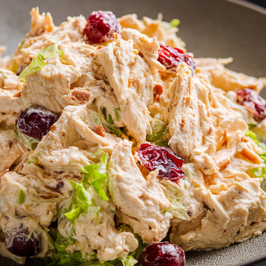 A plate loaded with chicken and salad.