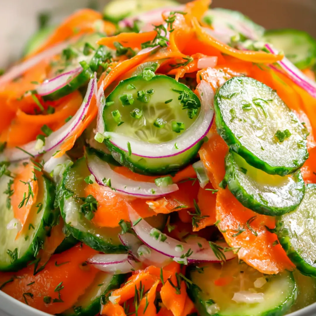 A bowl brimming with cucumbers, carrots, onions, and plenty of color.