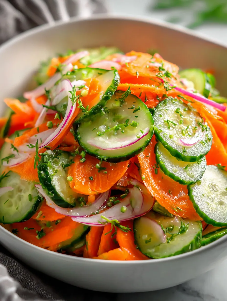 A bowl of vegetables including carrots and cucumbers.