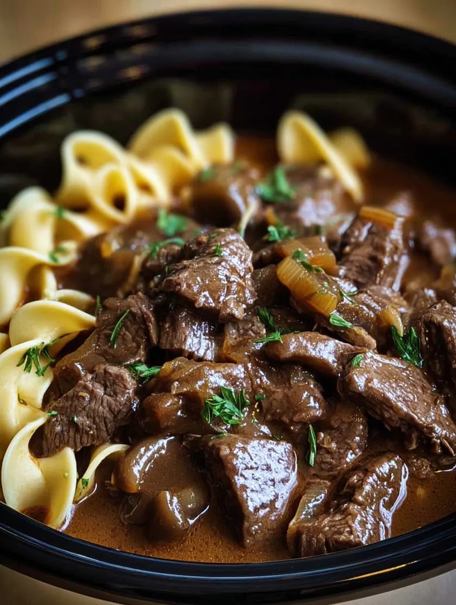 A bowl of beef stew with noodles.