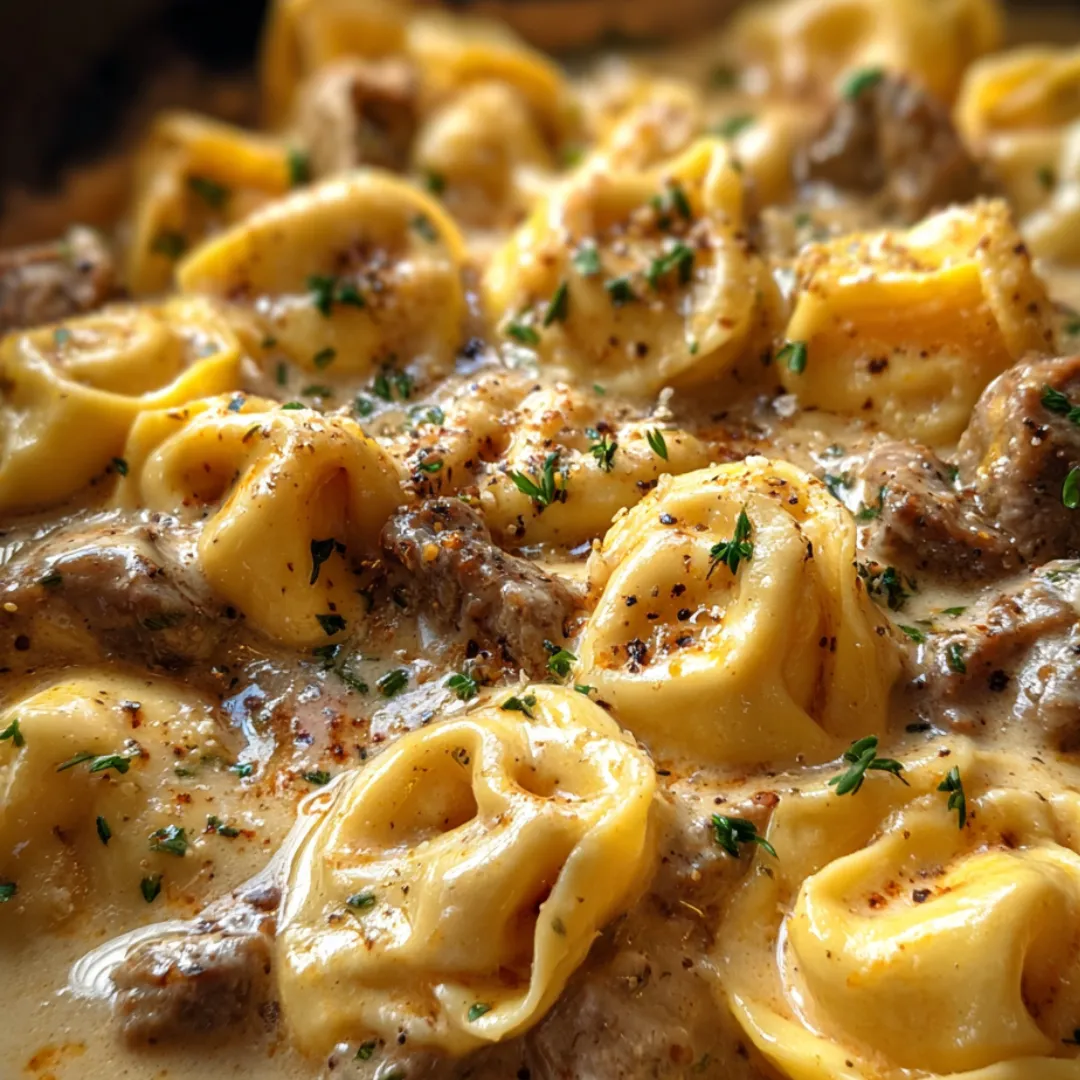 A comforting bowl featuring pasta, beef, and melted cheese.