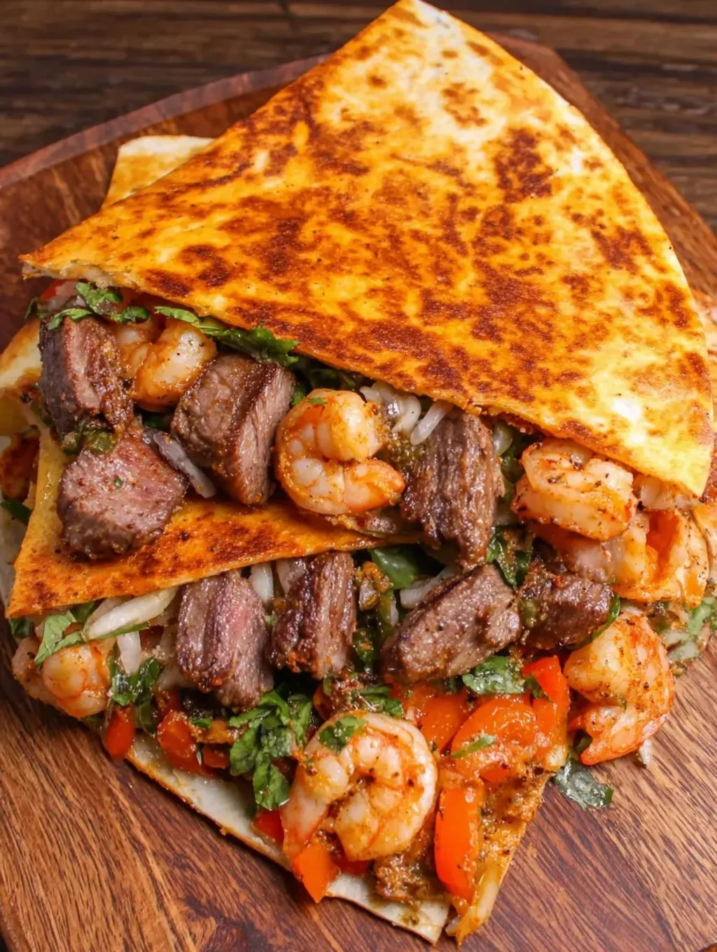 A burrito loaded with shrimp, steak, and lettuce.