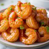 A plate of shrimp with green onions.