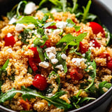A bowl of rice with tomatoes and cheese.
