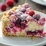 A slice of cake with berries on top.