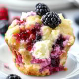 A cupcake with berries and cream.