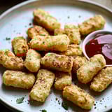 A plate of food with a ketchup dipping sauce.