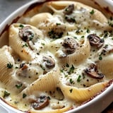 A bowl of pasta with mushrooms and cheese.