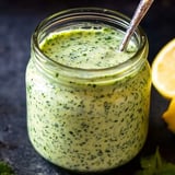 Bright green sauce in a clear jar, spoon ready for scooping.