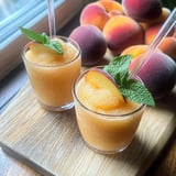 A pair of peach drinks topped with mint sprigs.