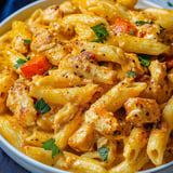 Pasta bowl filled with chicken and mixed veggies.