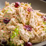A plate loaded with chicken and salad.