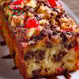A thick slice full of chocolate and cherries.